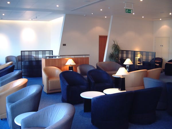 Empty armchairs and lamps in an airline business class lounge